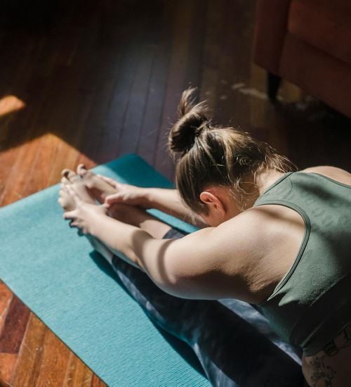 Woman practicing a morning yoga routine with sunlight.